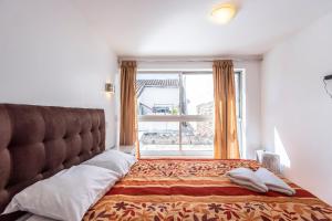 1 dormitorio con 1 cama grande y ventana en El Triunfo Apartments, en Cusco