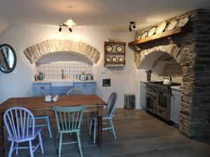 a kitchen with a wooden table and chairs and an oven at Charming Old Farmhouse in Coachford