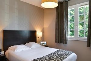 a bedroom with a large bed and a large window at Logis Hôtel Restaurant des Châteaux in Azay-le-Rideau +34 photos