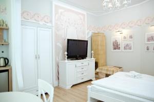 sypialnia z telewizorem na białej komodzie w obiekcie Deluxe appartment in the city center w Lwowie