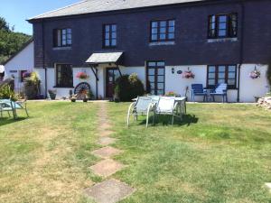 a house with a table and chairs in the yard at Coombe House B&B in Cawsand