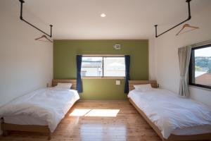 Akuneにある塩屋ホステルのベッドルーム1室(ベッド2台、窓付)
