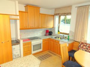 una pequeña cocina con armarios de madera y una mesa. en Appartement Christine, en Grossarl