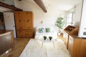 a living room with a white couch and a table at GregBnb - Centre ancien - CLIMATISÉ - T2 Mezzanine - 6eme étage in Toulon