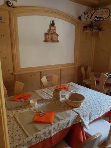 a dining room with a table with orange napkins and a tableablish at Agritur Coryletum in Coredo