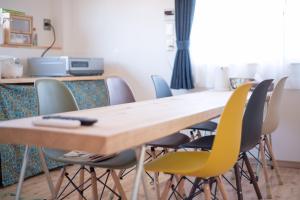 a conference room with a wooden table and chairs at Shioya Hostel in Akune