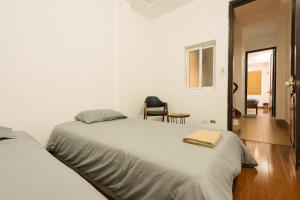 Un dormitorio blanco con 2 camas y una silla en Michi 6 en Hanoi