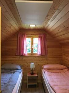 2 Betten in einem Holzzimmer mit Fenster in der Unterkunft Camp Podgrad Vransko in Vransko