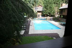 a swimming pool in a yard next to a house at LOGE Alta Crystal Resort at Mt Rainier in Enumclaw