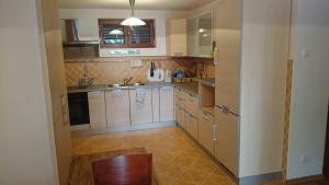 a kitchen with white cabinets and a wooden floor at BG Villa, Apartment L in Sutomore