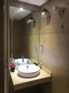 une salle de bain avec un lavabo et un miroir dans l'établissement Plage Des Nations Golf Resort, à Sidi Bouqnadel