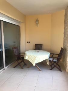 une table et deux chaises sur une terrasse dans l'établissement Plage Des Nations Golf Resort, à Sidi Bouqnadel