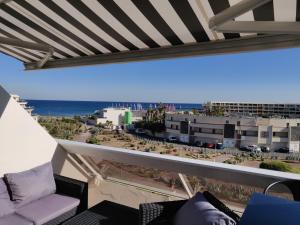 een balkon met uitzicht op het strand en de gebouwen bij Clubber Naturiste Design in Cap d'Agde