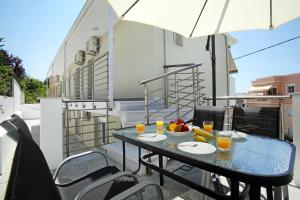 a table with glasses of orange juice on a balcony at SunsetPeramos in Nea Peramos