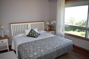 a bedroom with a bed with a pillow and a window at La Garita Casa Rural in Cangas de Morrazo