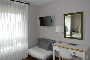 a room with a desk and a mirror and a chair at La Garita Casa Rural in Cangas de Morrazo