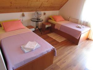 a room with two beds and a table with a fan at Guest House Nenad in Plitvička Jezera