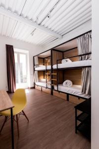 a room with three bunk beds and a table at Hostel Nüt in Granada