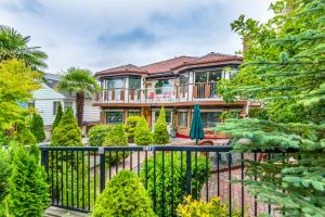 a house with a black fence and trees at Diana's Luxury Bed and Breakfast in Vancouver