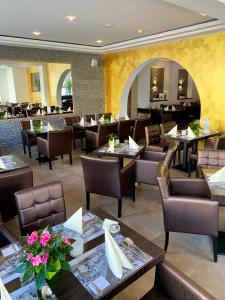 ein Esszimmer mit Tischen und Stühlen sowie ein Restaurant in der Unterkunft Boutique Hotel Goldene Henne in Wolfsburg