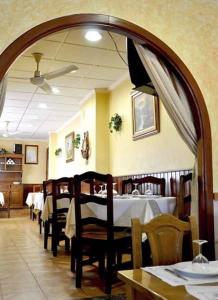 un comedor con mesas y sillas en un restaurante en Pensión Costiña, en Noia
