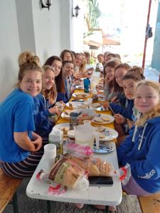 un gruppo di bambini seduti a un lungo tavolo di Ljubicica Hostel a Sarajevo