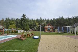 a backyard with a pool and a frisbee at Sosenka 6 - całoroczne domki rekreacyjne in Milicz +3 photos