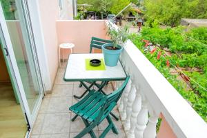 mały stół i 2 krzesła na balkonie w obiekcie Apartments Vesela w mieście Seline