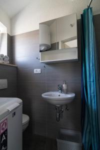 a bathroom with a sink and a toilet and a mirror at Studio apartment Matoni in Postira