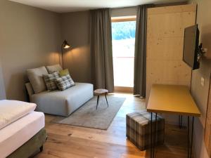 un soggiorno con letto e divano di Klein Fein Hotel zum Graf a Valle Di Casies Altre 36 foto