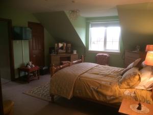 1 dormitorio con cama y ventana en Woodcockfaulds House, en Stirling