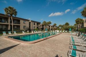a swimming pool with lounge chairs in a resort at Sea Club Condo #37 in Clearwater Beach