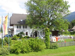 a house with a ivy covered tree in front of it at Landgasthof Pfeffermühle in Kötschach