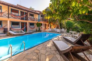 a pool in front of a building with a resort at Pousada Bemvirá in Arraial d'Ajuda