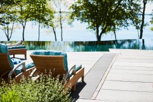 a patio with chairs and a fountain and trees at The Inn at Ocean's Edge in Lincolnville