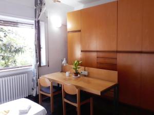 ein kleines Zimmer mit einem Holztisch und Stühlen in der Unterkunft Bed in Siena in Siena
