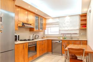 a kitchen with wooden cabinets and a stainless steel refrigerator at Apartment in Amdar Residence in Eilat