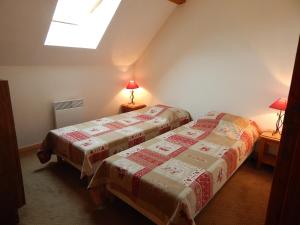 two beds in a small room with a window at Chevêche in Germ