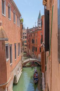 a canal with a bridge and a boat in the water at Canal View San Marco Luxury Rooms in Venice
