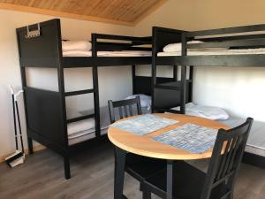 Habitación con literas, mesa, mesa y sillas. en Sörmarks Camping en Sörmark