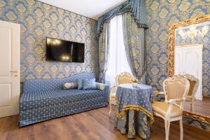 une chambre bleue avec un canapé et une table dans l'établissement Canal View San Marco Luxury Rooms, à Venise