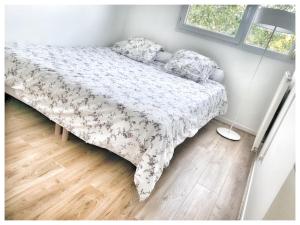 a bed with a comforter and pillows in a bedroom at Modern & Chic Appartement- GoodVibes Paris in Gonesse