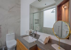 a bathroom with a sink and a mirror and a toilet at Hotel Casa Monarca in Puebla