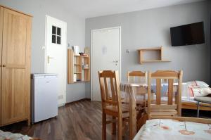 a room with a table and chairs and a bedroom at Pokoje gościnne U Jadzi in Chałupy