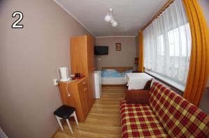 a small living room with a couch and a window at Pokoje gościnne U Jadzi in Chałupy