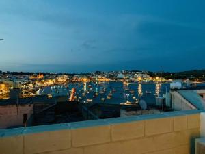 un puerto de noche con barcos en el agua en Anthony's Sea Stay en Marsaxlokk