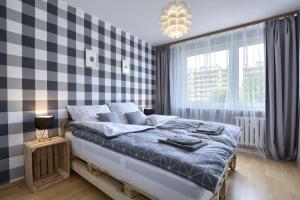 a bedroom with a bed and a checkered wall at Apartament Dzień Dobry 2 in Wałbrzych