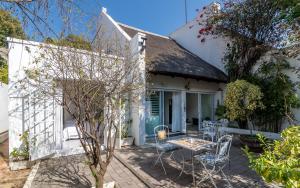 a white house with a table and chairs on a patio at Green Park Manor in Johannesburg +21 photos