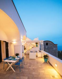 eine Terrasse mit Tischen und Stühlen auf dem Balkon in der Unterkunft Villa Marilisa in Conca dei Marini
