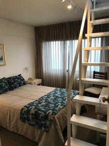 een slaapkamer met een bed en een wenteltrap bij Hotel Bariloche Flat in Bariloche